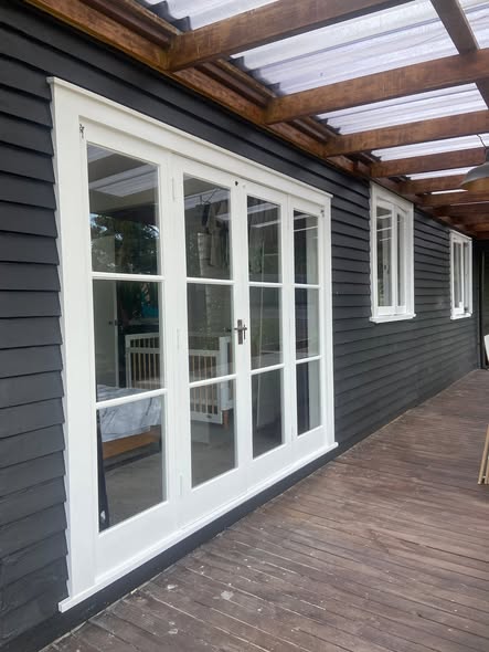 Dark weatherboard exterior with crisp white-framed doors